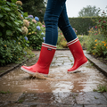 Aigle Malouine 2 rote Gummistiefel beim Laufen durch Pfütze im Garten